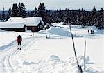 Suède, skieur de fond approchant les cabines enneigé