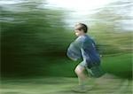 Young boy running, full length, blurred.