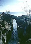 France, Normandy, natural bridge across gorge, sea in background