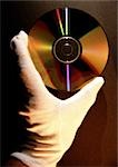 Gloved hand holding CD, close-up