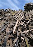 Large heap of wooden planks and pallets, blue sky in background