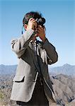 Man using camera, mountains in background