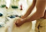 Person washing hands, focus on arms, blurred