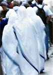 Israel, Jerusalem, nuns clothed in white looking toward crowd, rear view, blurry.