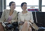 Two women sitting in airport lounge together