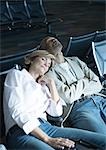 Travelers sleeping in airport lounge