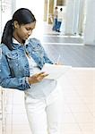 Teenager-Mädchen in Notebook stehen Schließfächer gelehnt, schreiben