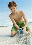 Boy making sand castle on beach