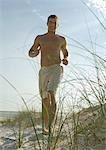 Man running in dunes on beach