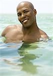 Man wading in sea, smiling