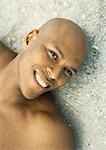 Man lying on wet sand