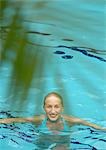 Femme à la piscine, souriant à la caméra