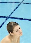 Femme près de piscine, les yeux fermés et souriant