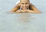 Woman lying in shallow water on beach