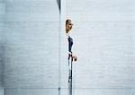 Woman looking out from behind wall