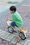 Boy riding bike with training wheels