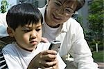 Father and son, boy looking at cell phone