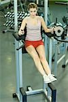 Woman using exercise machine, full length