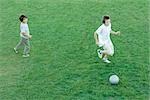 Two boys playing ball on lawn, high angle view