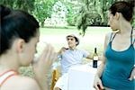 Family having meal outdoors, focus on man drinking wine