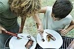 Boys sharing piece of grilled meat