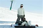 Snowboarders couché dans la neige, à la recherche à un ami