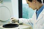 Young male researcher using centrifuge in lab