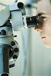 Young male scientist using microscope