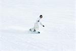 Young snowboarder on ski slope, mid-distance