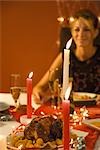 Woman eating candle lit dinner, selective focus