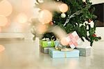 Cadeaux de Noël empilé sous arbre de Noël, vue à travers les lumières de Noël, mise au point sélective