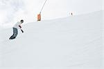 Snowboarder descending slope, low angle view