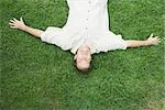 Man lying on back on grass, smiling at camera, viewed from directly above