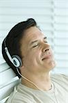 Man listening to headphones, smiling, eyes closed