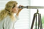 Woman looking through telescope, side view