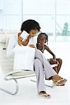 Mother sitting next to daughter, holding up gift, both smiling