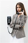 Teen girl using landline phone, looking at camera