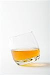 Glass of whiskey tipping, close-up