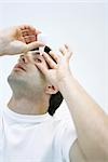 Man applying eye drops, head back