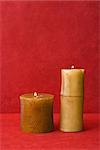 Two pillar candles, side by side, burning