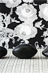 Three polished pebbles in row against patterned background, cropped