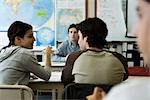 High school student speaking with classmate in class