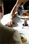 Closeup of couple at dinner table with hands touching