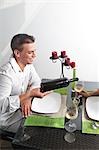 Young man pouring wine for young woman at restaurant table