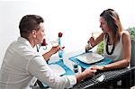 Couple sitting at table drinking white wine