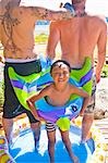 tattoed men and boy in wading pool at beach