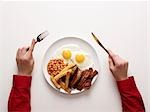 hands next to a fried breakfast