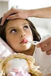 Mother checking daughter's temperature, caressing forehead, cropped