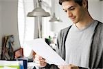 Man with look of satisfaction reading document