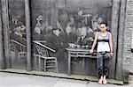 China,Sichuan Province,Dujiangyan city. A girl posing infront of a old 3D wall painting